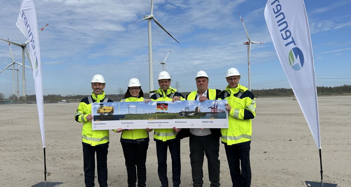 Zu sehen sind fünf Menschen mit Bauschutzausrüstung auf einem Baufeld vor Windkraftanlagen, Puzzleteile präsentierend. Tim Meyerjürgens (Tennet), Ina Kamp (Tennet), Olaf lies (Ministerpräsident), Carsten Feist (OB WHV), Alexander Leonhardt (Wirtschaftsflörderung WHV)