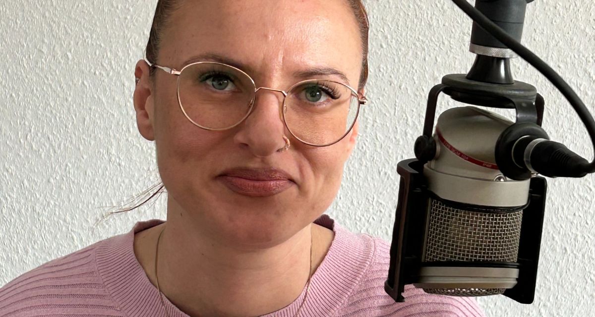 Zu sehen ist eine Ftrau im Rundfunkstudio, Blick in die Kamera