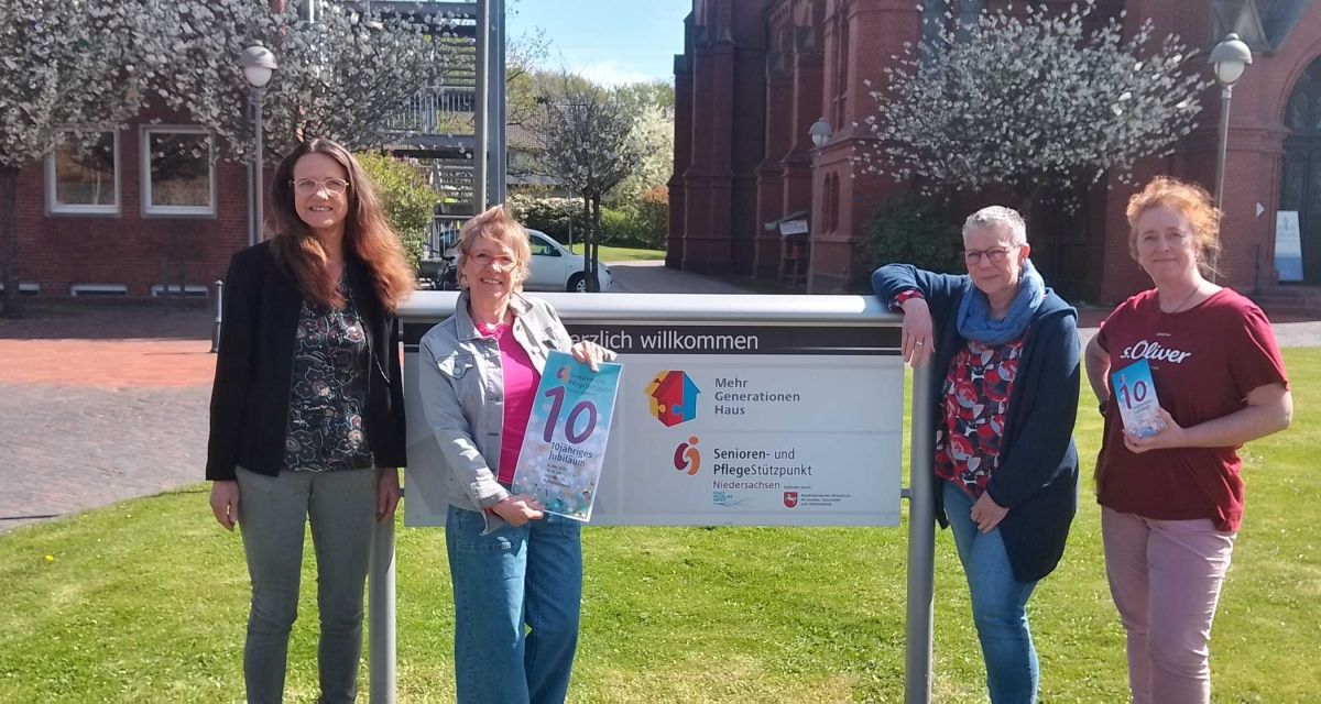 Das Programm zum 10-jährigen Jubiläum des Senioren- und Pflegestützpunkts Niedersachsen in Wilhelmshaven wird vorgestellt. Vor dem Eingangsschild an der Banter Kirche stehen (von links nach rechts): Pastorin Anke Stalling, Isabell Eickhoff vom Seniorenstützpunkt und Jutta Rahmann und Monika Abels vom Pflegestützpunkt.