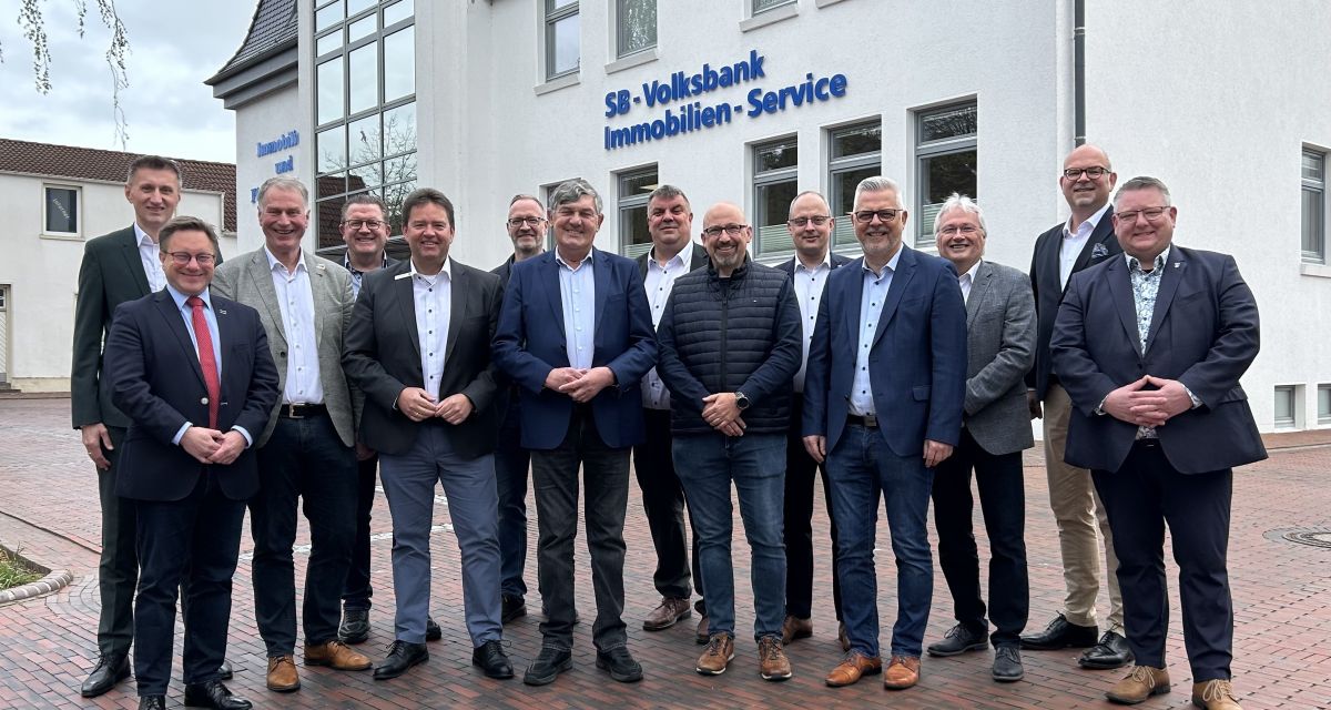 Zuu sehen sind Verwaltungsspitzen eines Dutzendes regionaler Gebietskörperschaften und Vertreter der Volksbank Jade Weser vor dem immobilienzentrum des Institues in Jever