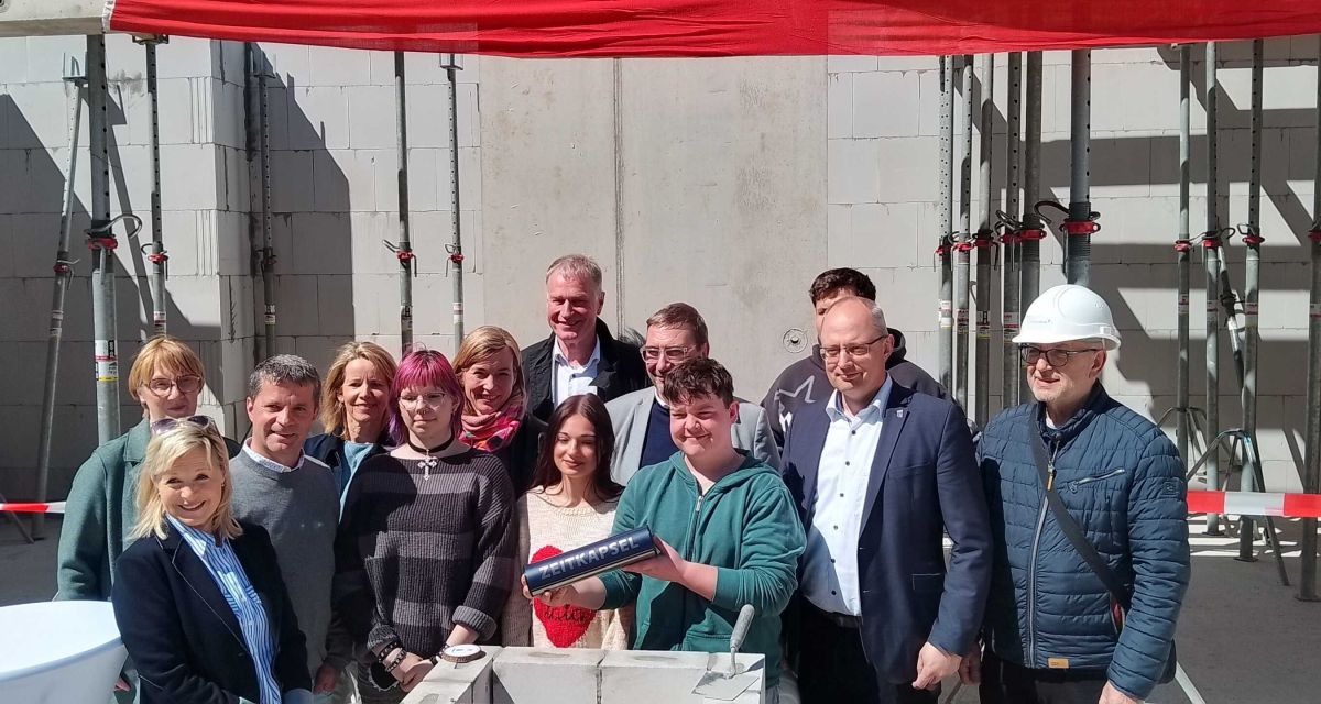 Grundsteinlegung für die Heinz-Neukäter-Schule in Varel. Die Zeitkapsel wird eingesetzt, zu sehen sind u.a. Landrat Sven Ambrosy, Bürgermeister Gerd-Christian Wagner, Schulleiterin Sandra Heidenreich, Bundestags- und Kreistagsabgeordnete Siemtje Möller, Dezernent für Planung und Infrastruktur beim Landkreis Rolf Neuhaus, Architektin Ursula Pasch vom Architekturbüro Brüchner-Hüttemann Pasch aus Bielefeld, der stellvertretende Landrat Fred Gburreck und Schüler*innen der Schule.