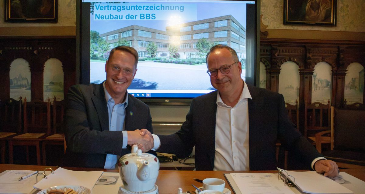 Landrat des Landkreis Wittmund Holger Heymann und einer der Geschäftsführer der Baufirma August Prien Markus Buchhorn bei der Unterzeichnung des Vertrags für den Neubau der BBS