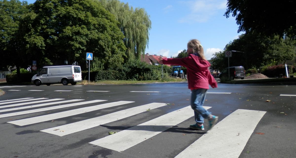 Ein Kind überquert einen Zebrastreifen in Schulnähe.