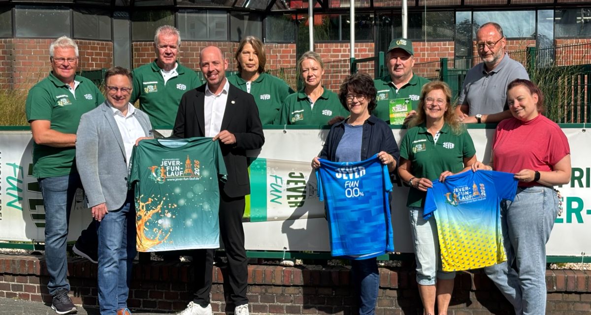 Zu sehen ist das Organisations-Team des Jever Fun Laufs 2026. Die Gruppe steht vor dem Friesischen Brauhaus zu Jever, es werden T-Shirts präsentiert, mit dem Schriftzug des Laufs. Der Traditionslauf findet zum zweiten Mal in Jever statt.