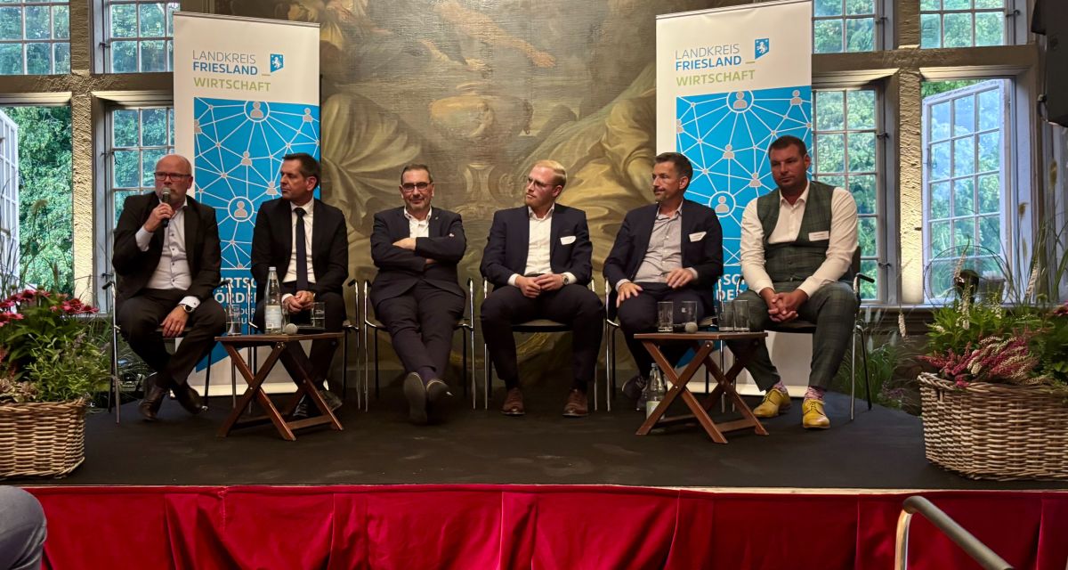 Im Saal von Shcloss Gödens sitzen Vertreter mittelständischer betriebe mit Landrat Sven Ambrosy und Ministerpräsident Olaf Lies auf dem Podium