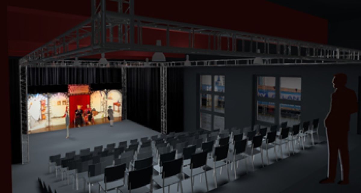 99 Stühle vor einer Bühne. darauf 2 Schauspieler im Rampenlicht. 