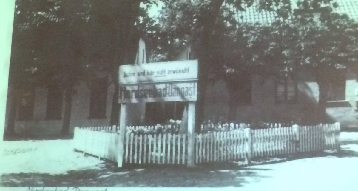 Zu sehen ist ein Schwarzweißfoto aus der Nazi-Zeit vom Eingang des Nordseebades Dangast. Auf einem Schild steht: