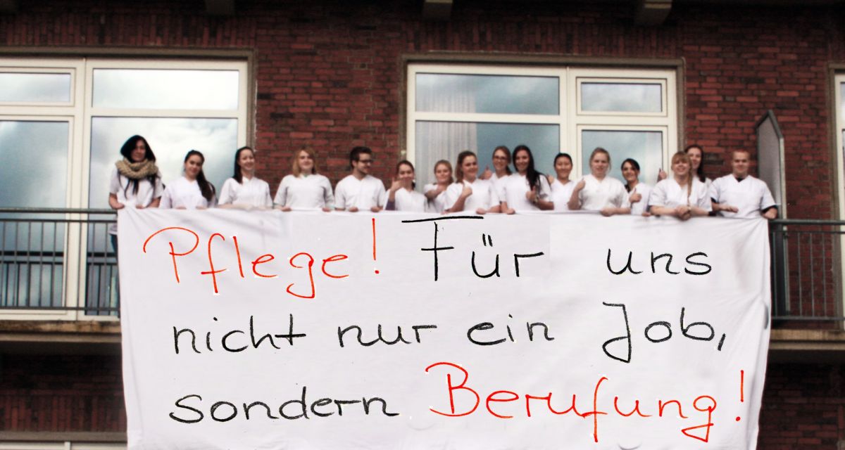 Mehrere junge Menschen halten auf einem Balkon das Transparent: 