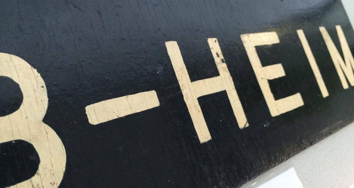 Ein schwarzes Schild mit weißen Lettern: B - HEIM