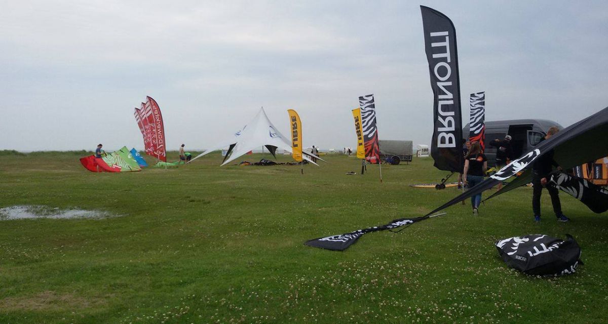 Auf der Wiese sind verschiedene Banner zu sehen sowie ein Zelt. Die Aufbauarbeiten für die Beach Days sind in vollem Gange.