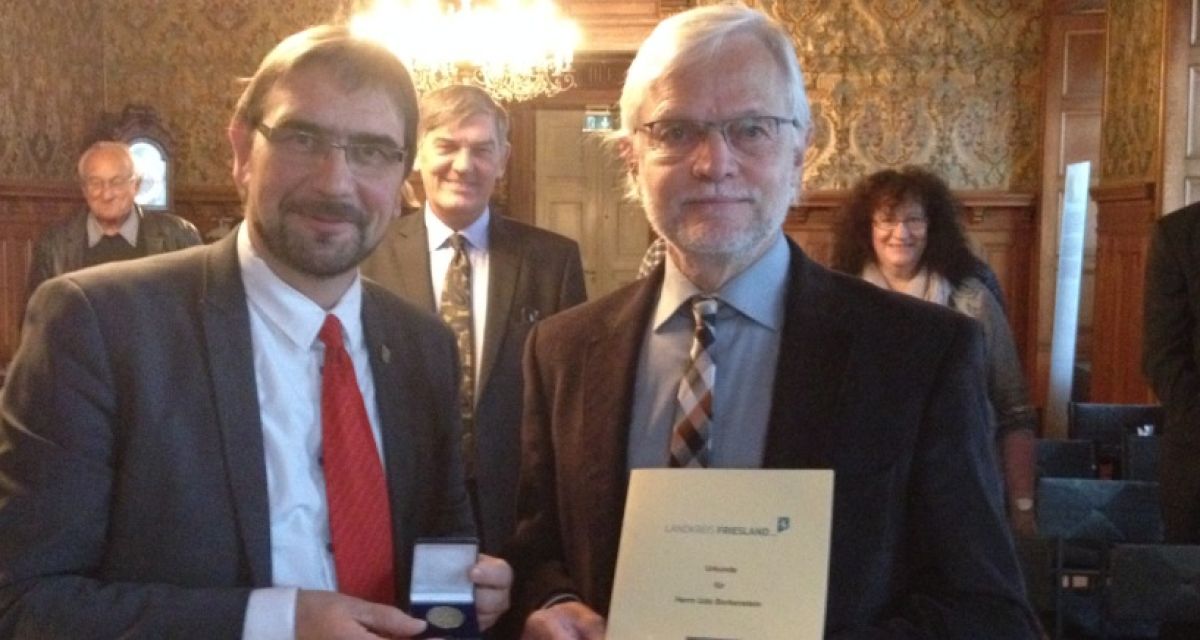 Udo Borkenstein erhält von Landrat Sven Ambrosy die Friesland-Medaille.