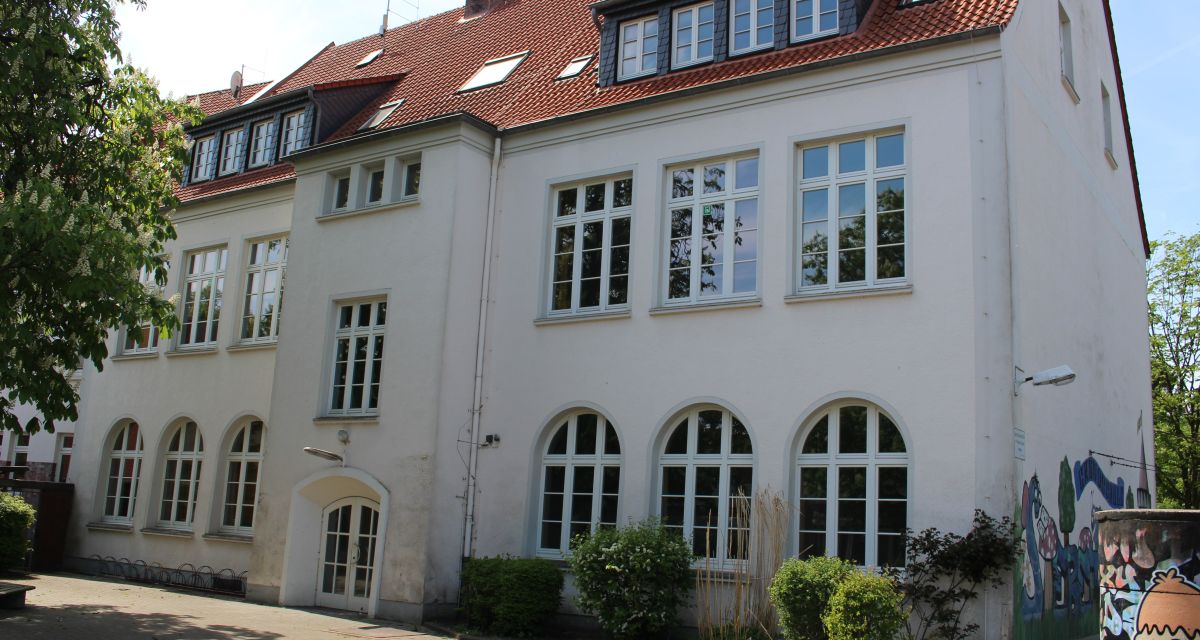 Es ist die Grundschule Siebethsburg von der Schulhofseite aus zu sehen.