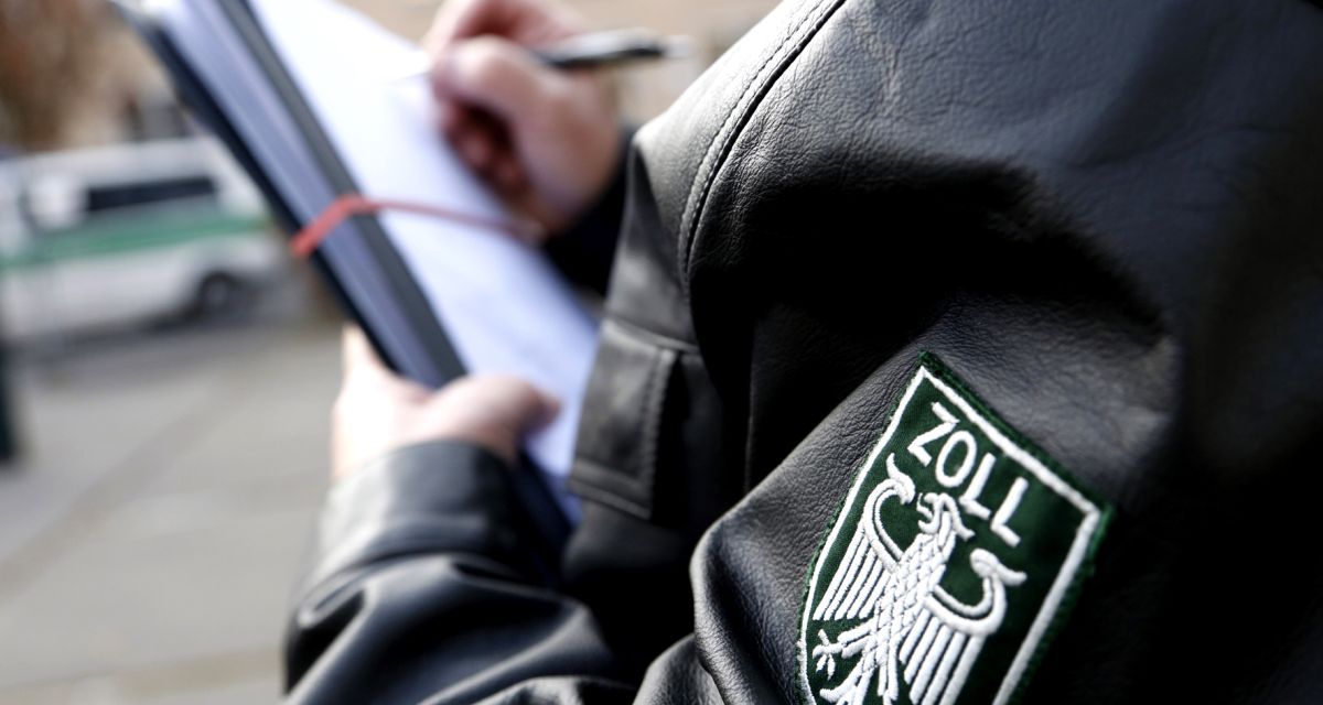 Zu sehen ist das Abzeichen des Zolls: ein weißer Adler auf dunkelgrünem Grund.
