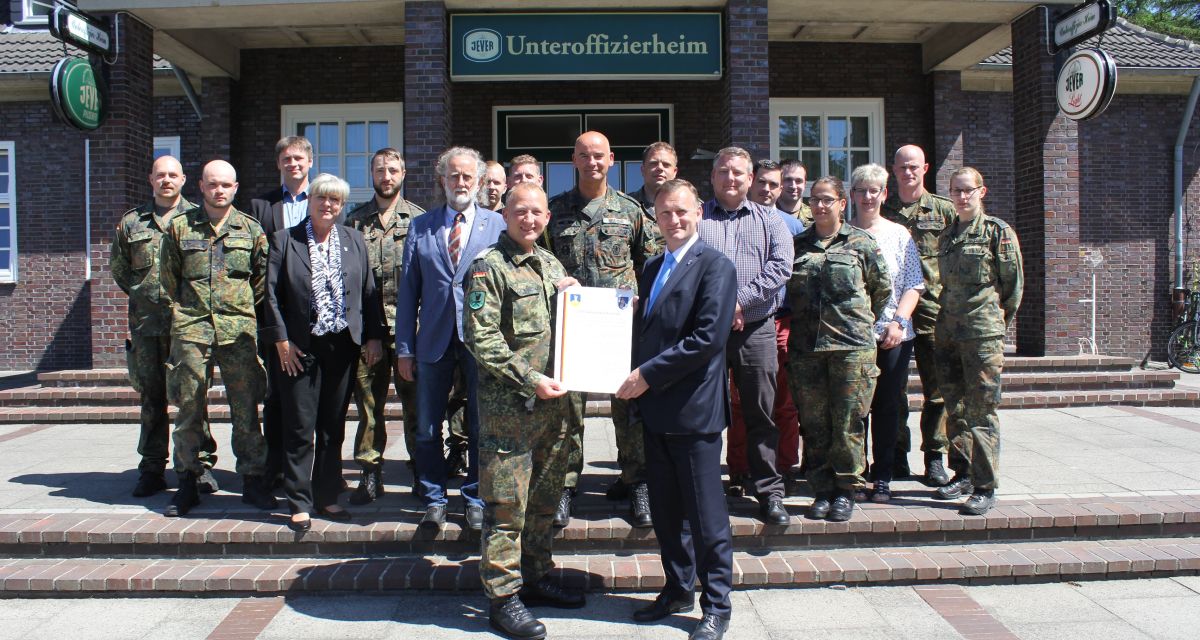 Oberstleutnant Frank Dröge und Bürgermeister Björn Mühlena mit Angehörigen des
Bataillons und der Gemeinde Wangerland vor dem Unteroffizierheim.