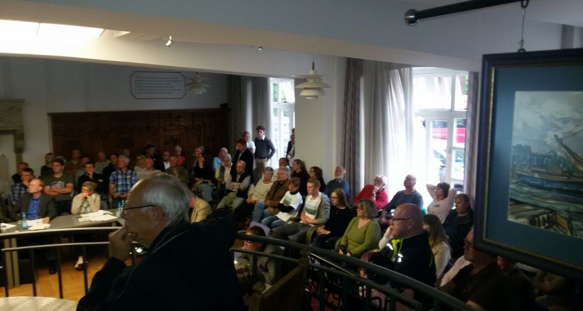 Zu sehen ist eine Gruppe von Menschen, die an einer Ausschusssitzung teilnehmen.