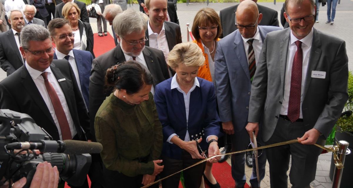 Ministerin  von der Leyen schneidet ein goldenes Band durch.