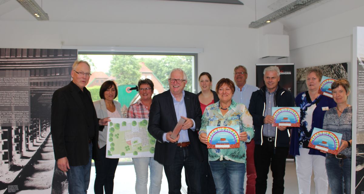 Mehrere Menschen posieren mit Schildern, auf denen