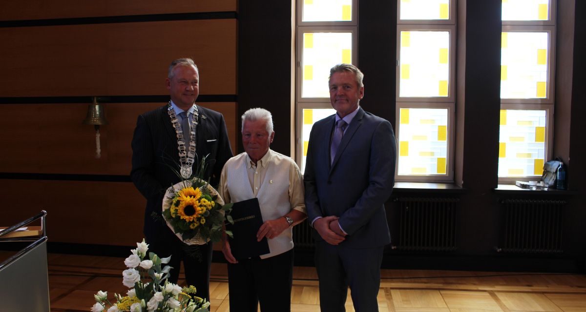 August Desenz wird die Ehrenbürgerwürde der Stadt Wilhelmshaven zuteil. Desenz steht im Ratssaal des Rathauses, zu seiner rechten der Oberbürgermeister Andreas Wagner, zu seiner linken Stefan Becker