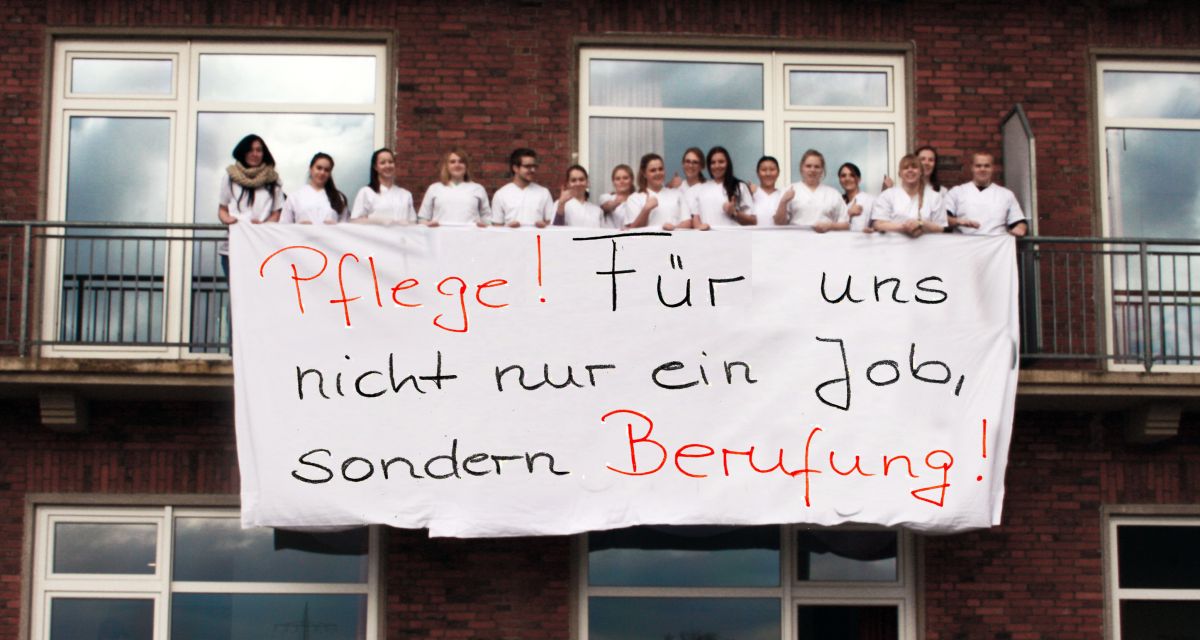 Mehrere junge Menschen halten auf einem Balkon das Transparent: 