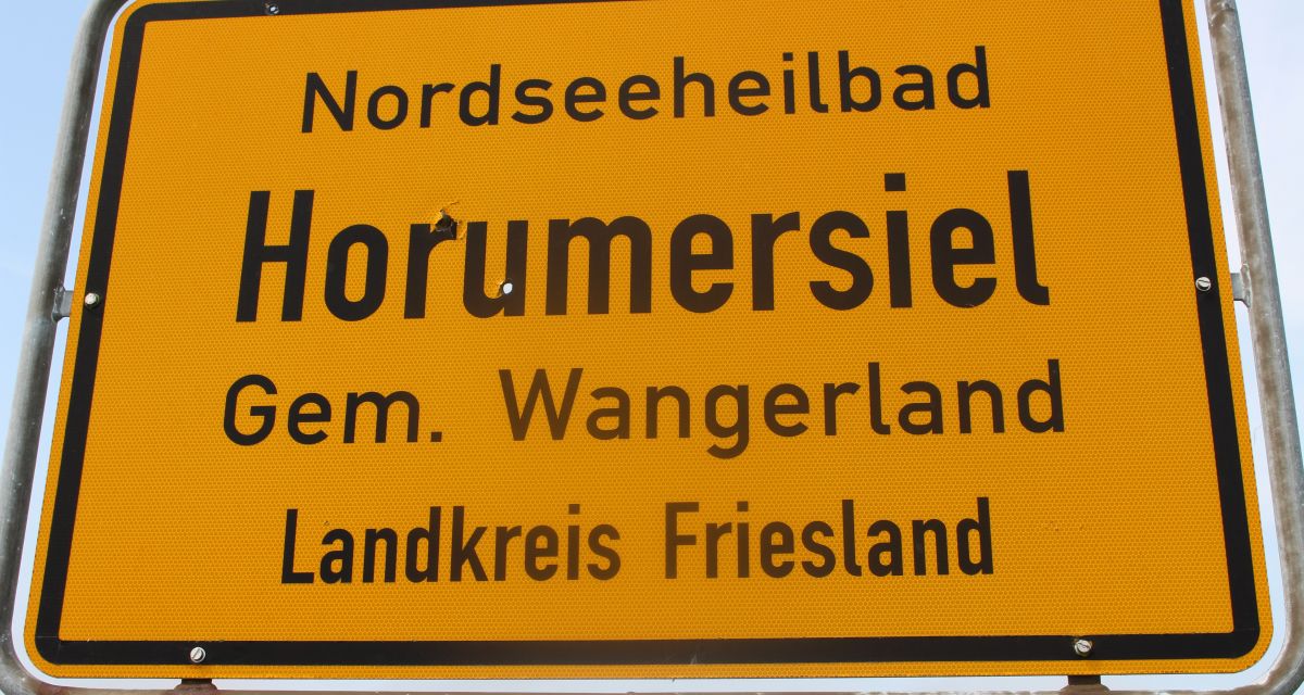 Ein gelbes Schild am Ortseingang von Horumersiel.
