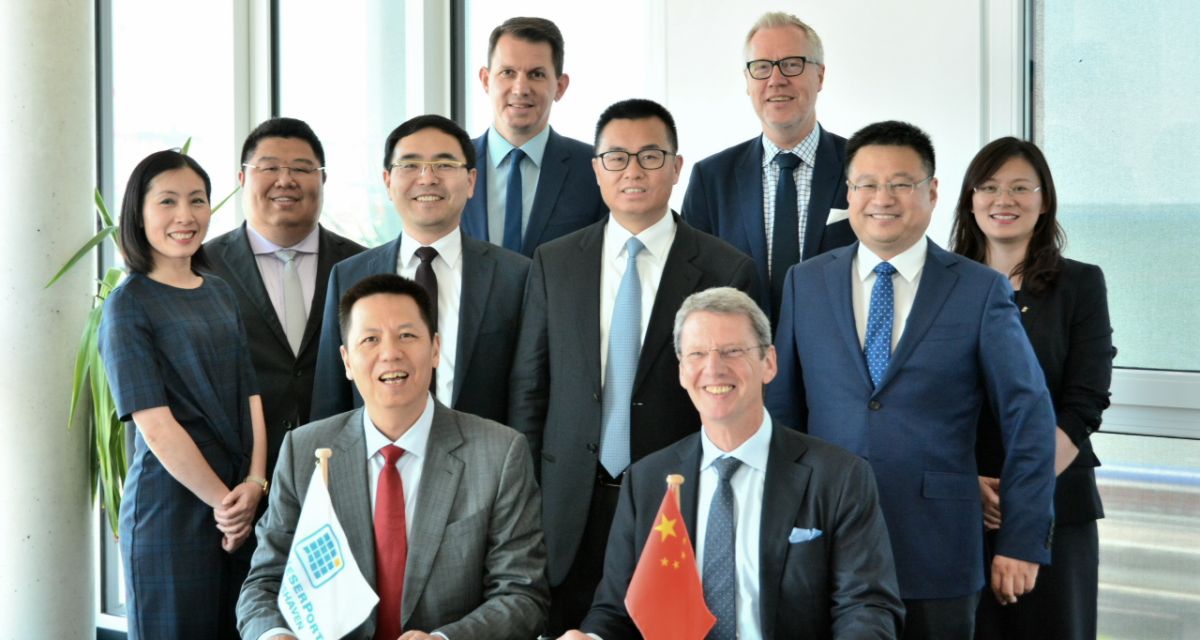 Menschen stehen hinter einem Schreibtisch. Darauf liegen Unterlagen zur Willenserklärung für ein Logistikzentrum an JadeWeserPort. Auf dem Foto von links nach rechts:
1. Reihe: Herr Li Xiangyang (CL General Manager) und
Herr Andreas Bullwinkel (JWPM)
2. Reihe: Frau Zhang Shuangyan (EUROGATE), Herr Zhang Hui (JWPM), Herr
Wang Jingsong (CCT), Herr Tong, Laiming (Vice President CCT), Herr Fu Zixuan
(CL), Frau Shi Stephanie (Weifang Center Germany)
3. Reihe: Herr Jörn Kamrad (EUROGATE) und Herr Ingo Meidinger (JWPM)