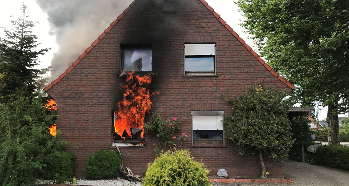 Zu sehen ist ein brennendes und qualmendes Wohnhaus.