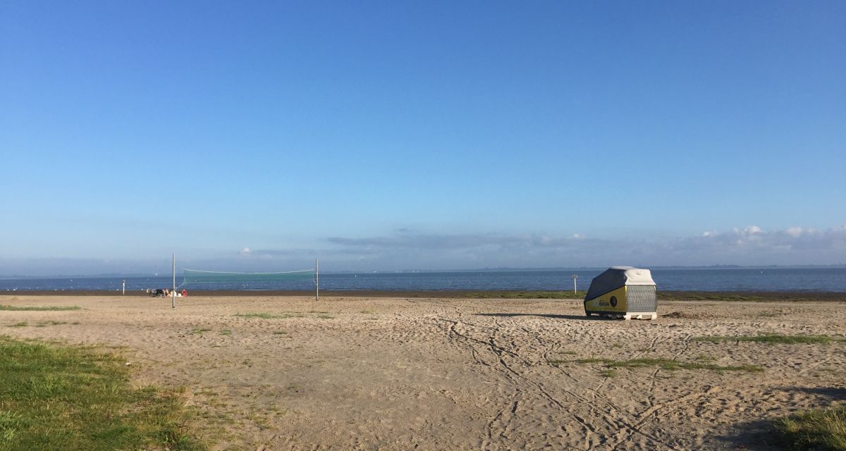 Man sieht den Schlafstrandkorb in Dangast unter blauem Himmel