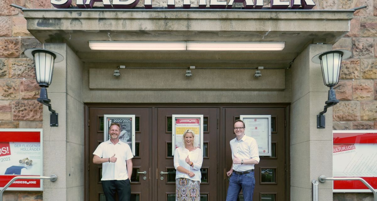 Zu sehen sind Olaf Strieb, Sandra Neumann und Torben Schumacher vor der Tür des Stadttheaters in Wilhelmshaven. 
