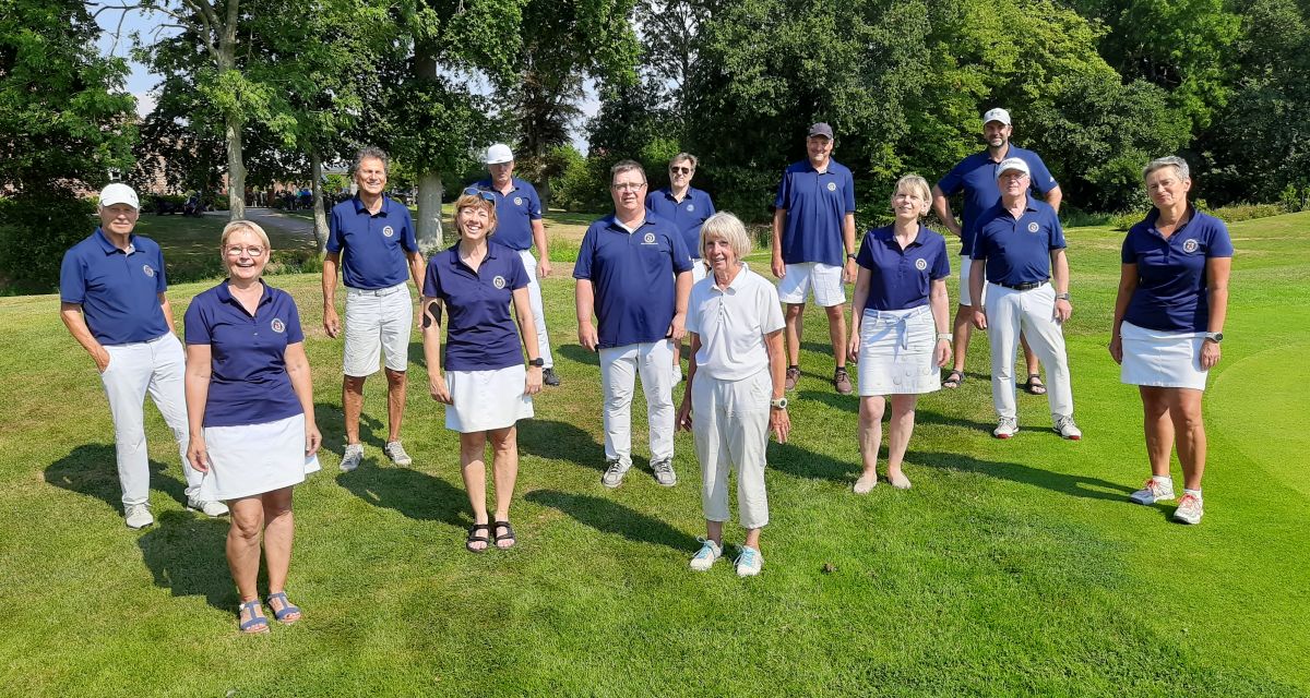 Mehrere Golfspieler und -spielerinnen auf einem Platz