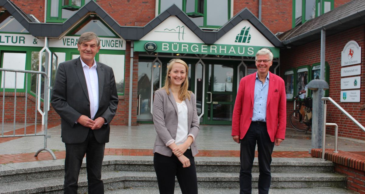 Bürgermeister Gerhard Böhling, Uwe Burgenger und Lotta Klein stehen vor dem Bürgerhaus Schortens. Lotta Klein sit die neue Kulturkoordinatorin Schortens.