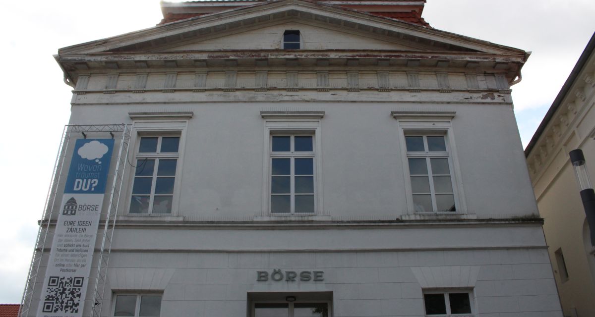 Die alte Börse in Varel aus der Froschperspektive. Hinter dem Gibel scheint die Sonne hervor 