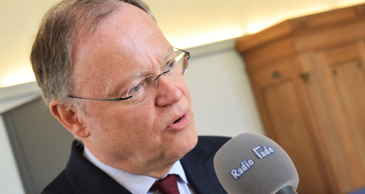 Zu sehen ist Stephan Weil, während er in ein Mikrofon von Radio Jade spricht. 