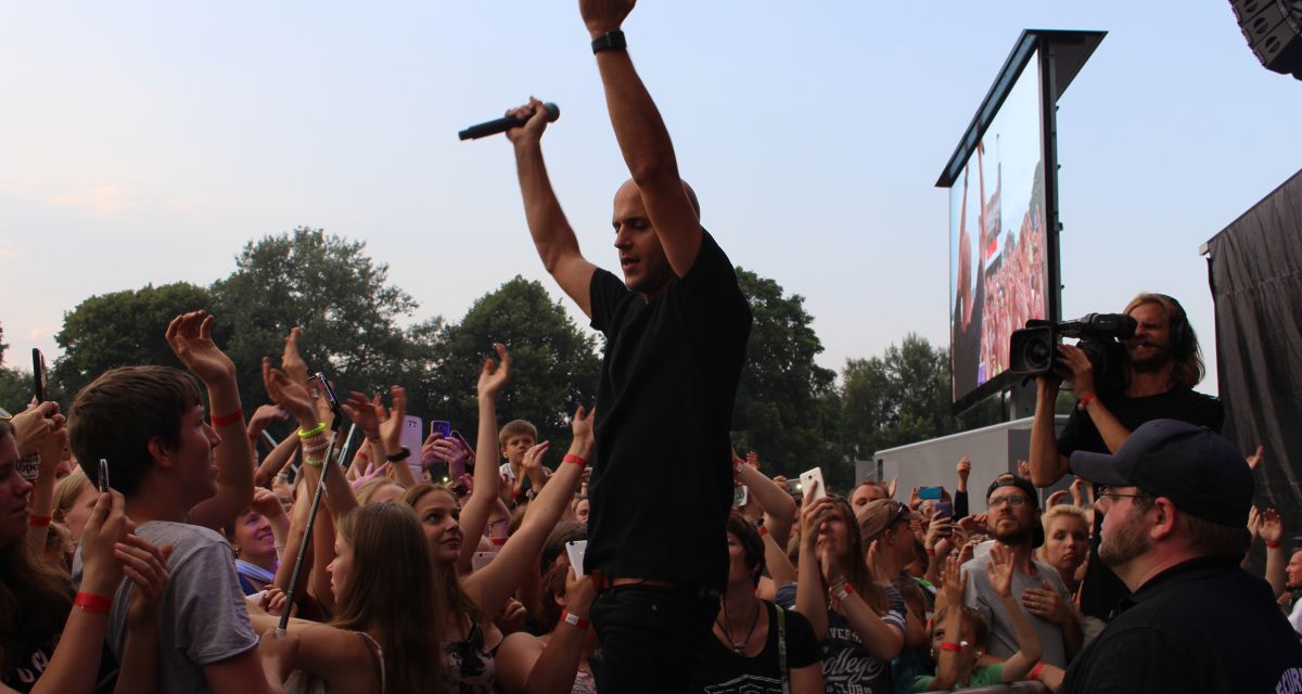 Zu sehen ist der Sänger Milow bei stars@ndr2, während er die Hände in die Luft streckt.