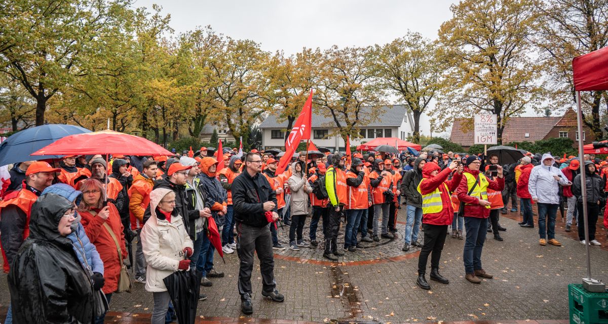 Kundgebung der IG Metall Küste, Menschen mit roten Fahnen und Kleidung