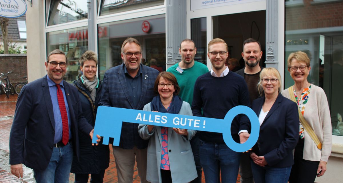 Vertreter*innen von GPS, Landkreis Friesland und Stadt Jever halten einen übergroßen Schlüssel zur Eröffnung des GPS-Shops in Jever hoch