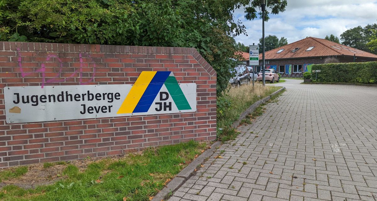Der Eingangsbereich zur Jugendherberge Jever. Auf einer Backsteinwand sind das Logo und die Aufschrift