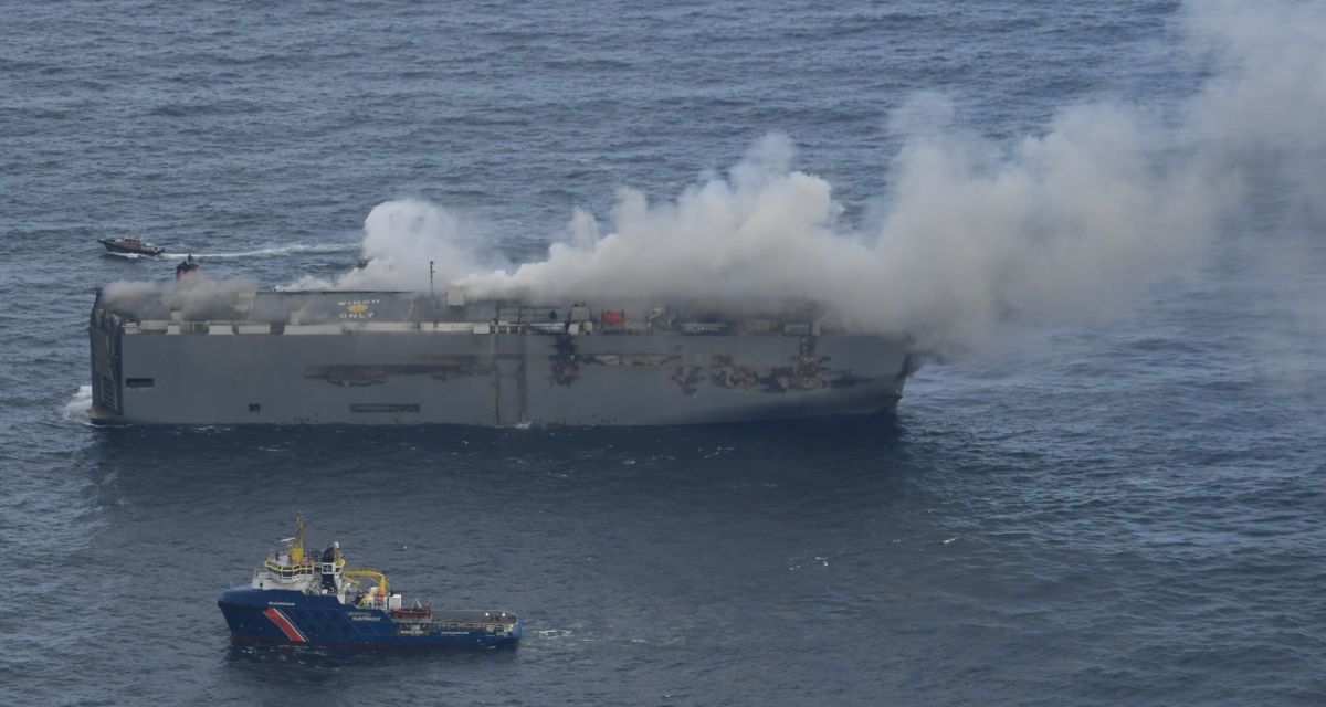Ein Schlepper der Küstenwache vor der brennenden und qualmenden Fremantle Highway