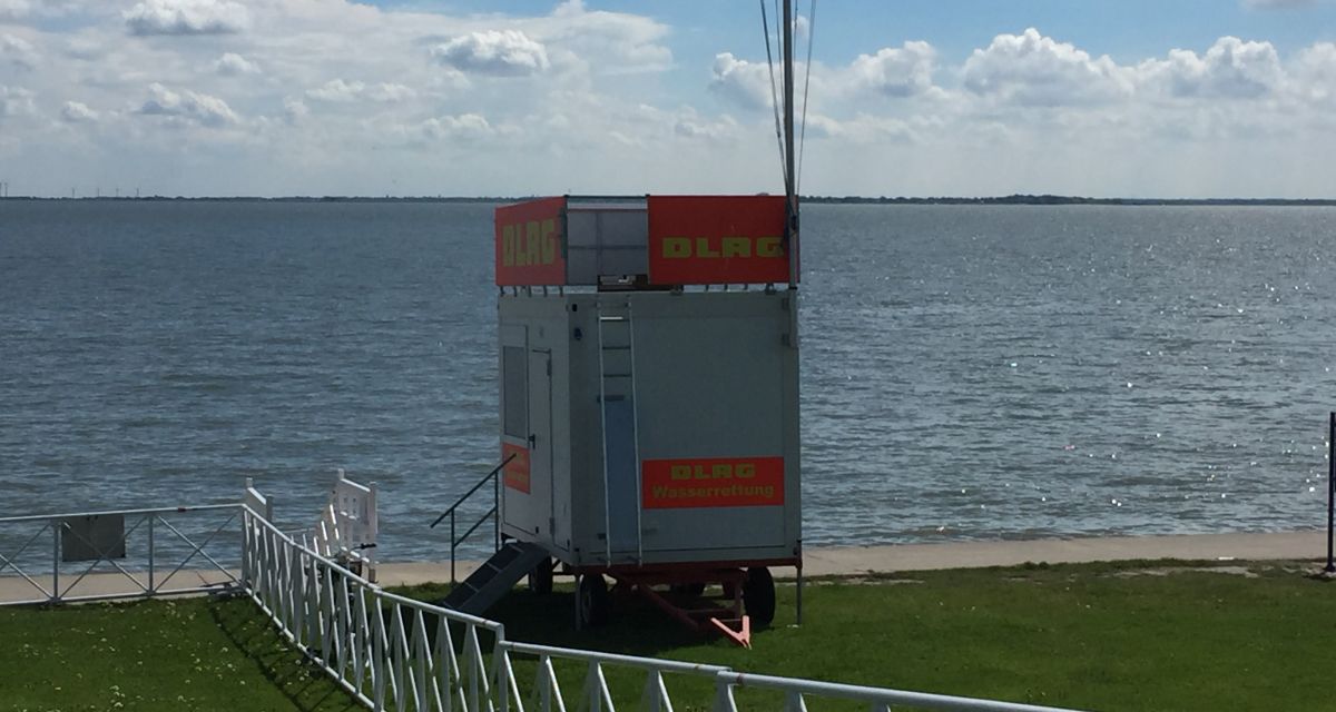 Ein DLRG-Container am Südstrand von Wilhelmshaven an einem sonnigen Tag.