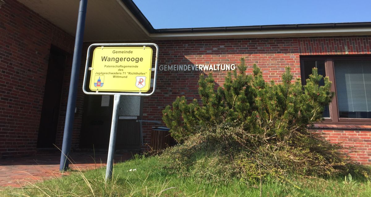 Das Ortsschild der Gemeinde Wangerooge vor dem Verwaltungsgebäude.