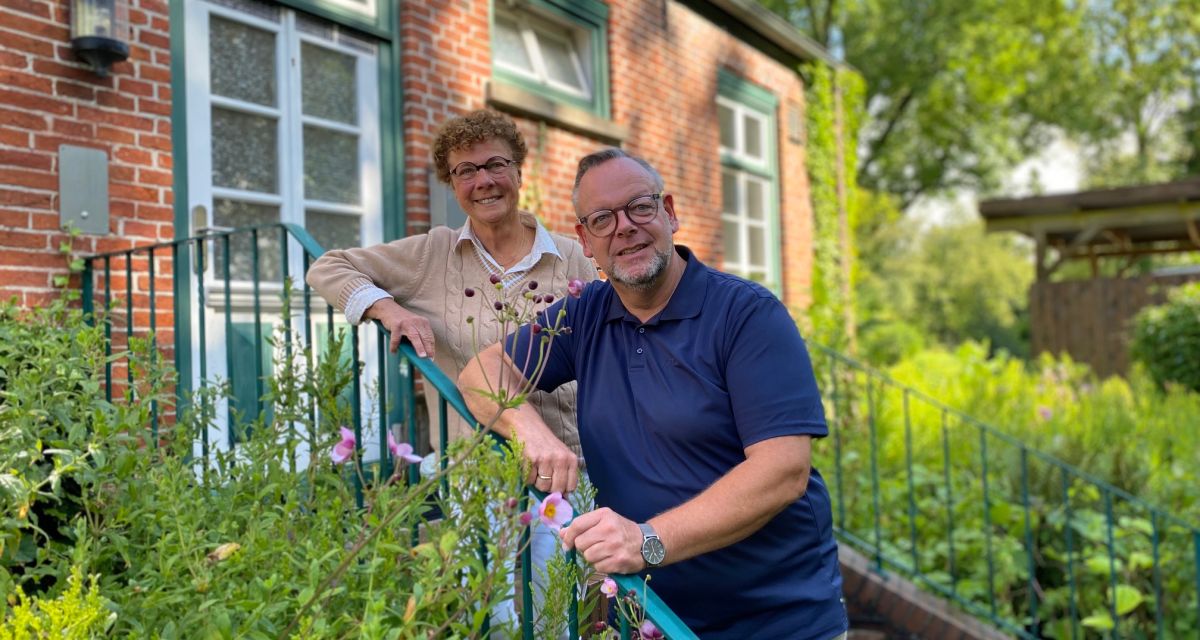 Die scheidende Leiterin der Telefonseelsorge, Christhild Roberz und der Kreispfarrer Christian Scheuer lehnen gemeinsam an einem Treppengeländer.