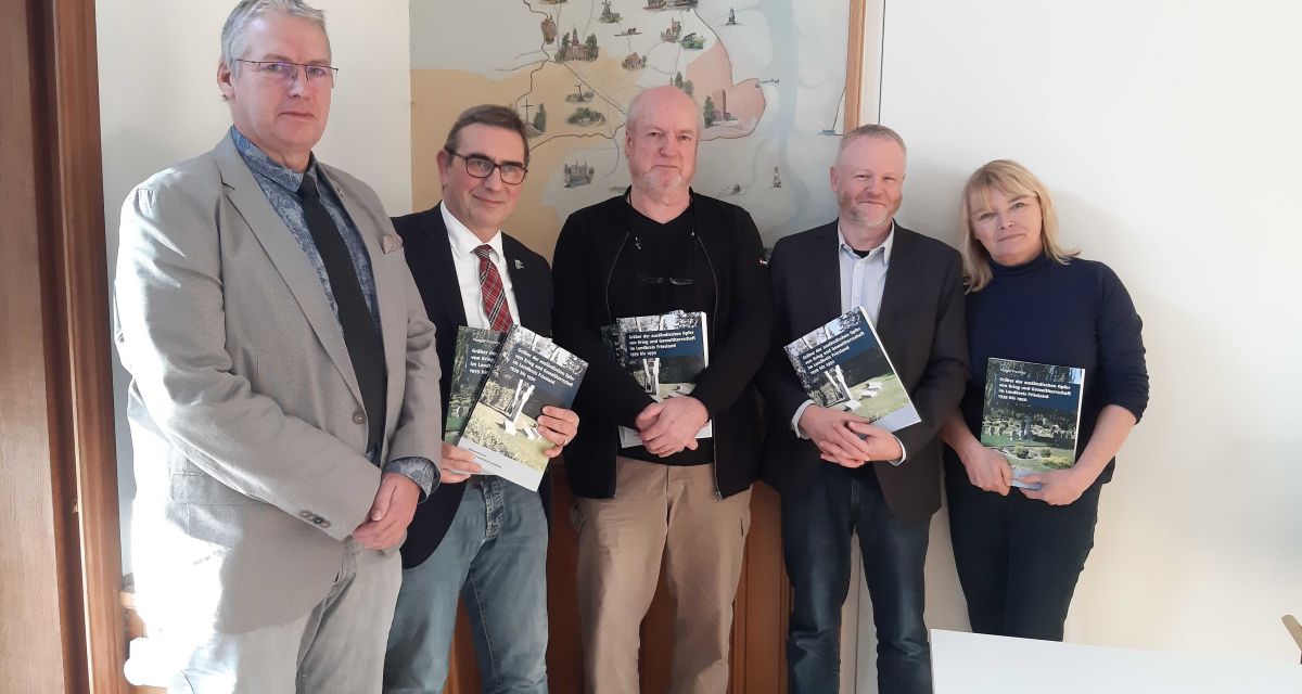 Vertreter*innen von Landkreis und Kriegsgräberfürsorge halten die Publikation 