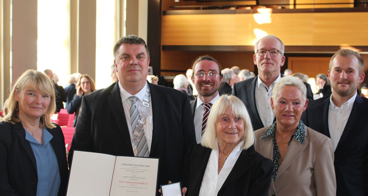 Christa Marxfeld-Paluszak erhält für ihr soziales Engagement das Bundesverdienstkreuz im Ratssaal des Rathauses in Wilhelmshaven. Neben ihr stehen unter anderem Antje Sander vom Schlossmuseum Jever, Oberbürgermeister Carsten Feist, der Landtagsabgeordnete Marten Gäde und Bürgermeisterin Gesche Marxfeld.