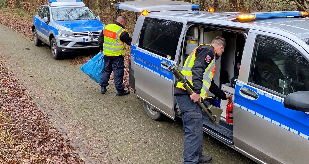 Zwei Mitarbeiter des Kampfmittelbeseitigungsdienstes Niedersachsen holen Gerätschaften aus einem Transporter. Sie tragen gelbe Wanrwesten mit der Aufschrift