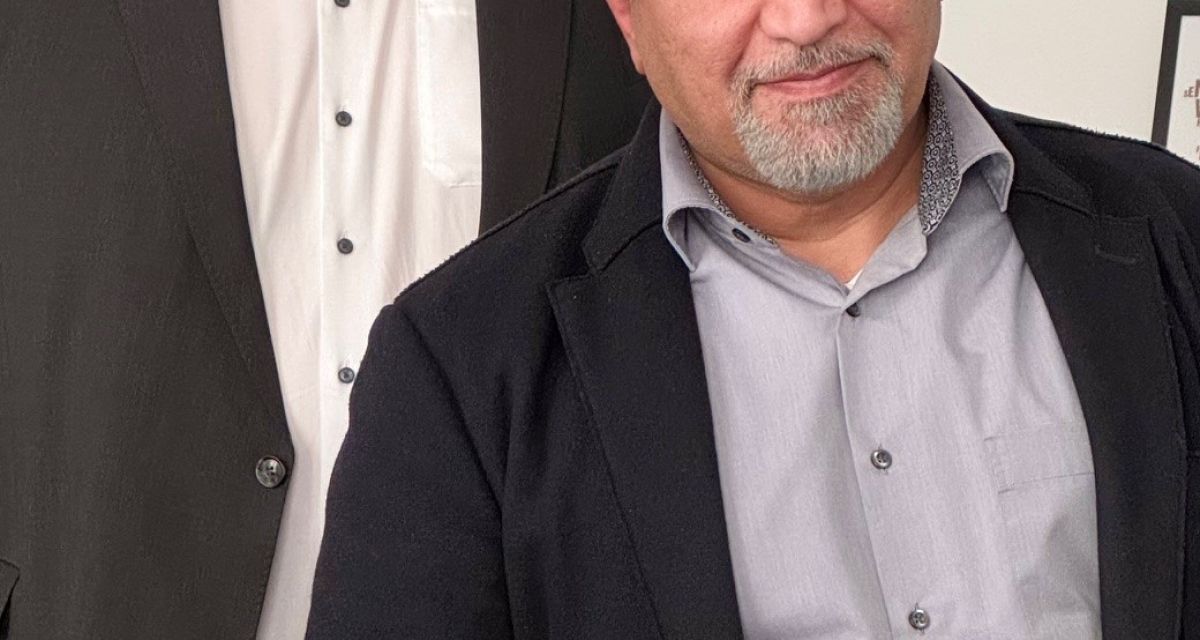 Der Oberbürgermeister der Stadt Wilhelmshaven, Carsten Feist, und der neue Geschäftsführer der Wilhelmshaven Entsorgungszentrum und Logistik GmbH, Iskender Evin, stehen vor einem Bild vom Nassauhafen.