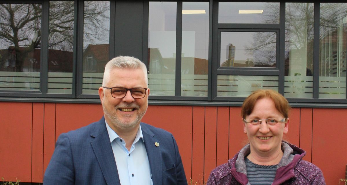 Zu sehen sind Sandes Bürgermeister Stephan Eiklenborg und die neue Gleichstellungsbeauftragte der Stadt, Andrea Tjarks. Die beiden stehen vor dem Rathaus in Sande.