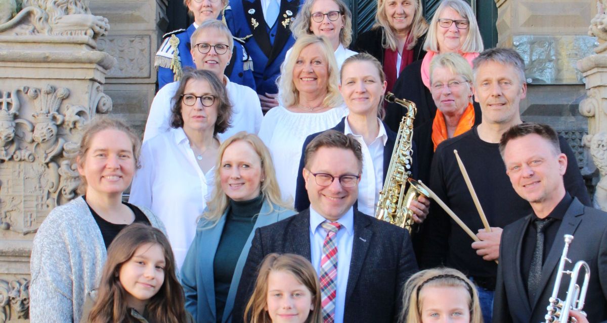 Zu sehen ist Jevers Bürgermeister Jan Edo Albers mit Vertretenden der Musikgruppen von 