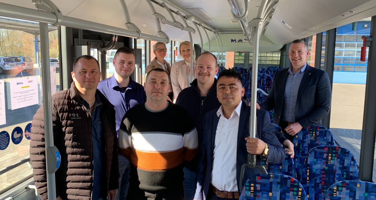 Die Arbeitsoffensive für Geflüchtete, initiiert vom Landkreis Friesland, ist in Varel ein Erfolg. Die Bruns Omnibusverkehr GmbH hat durch eine Jobmesse für Geflüchtete sechs neue Busfahrer*innen einstellen können. Drei von ihnen sind (erste Reihe, von links) Oleksandr Tiutiunnyk und Dmytro Moskalov (beide aus der Ukraine), und Khalmorad Uzbak (aus Afghanistan). Dahinter sind zu sehen (von links): Tammo Janßen (Fahrdienstleiter), Anne Hanenkamp (Leiterin des Arbeitgeberservices im Jobcenter Friesland), Wencke Burkhardt (stellvertretende Leiterin des Jobcenters Friesland), Torben Kirchner (Verkehrsplaner und Fahrdienstleiter) und Andreas Bruns (Leiter des Jobcenters Friesland).
