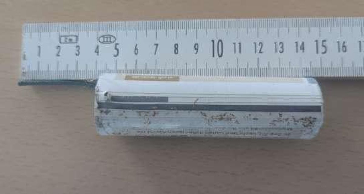 Zu sehen ist ein selbstgebauter pyrotechnischer Gegenstand, der in Jever aufgefunden wurde. In der Marienstadt hatte es zuletzt mehrere Detonationen gegeben, die auf solche selbstgebaute Pyrotechnik zurückzuführen sein können. Laut abgebildetem Maßstab ist der Gegenstand etwa zehn Zentimeter lang und etwa zweieinhalb Zentimeter breit und beinhaltet unter anderem aufgerolltes Papier.