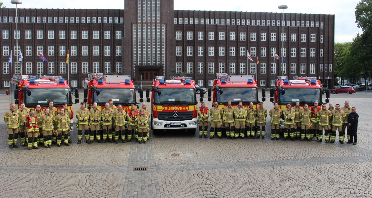 Zu sehen sind einige Männer und Frauen der Feuerwehr Wilhelmshaven auf dem Rathausplatz. Die Menschen stehen vor fünf neuen Hilfeleistungslöschgruppenfahrzeugen.