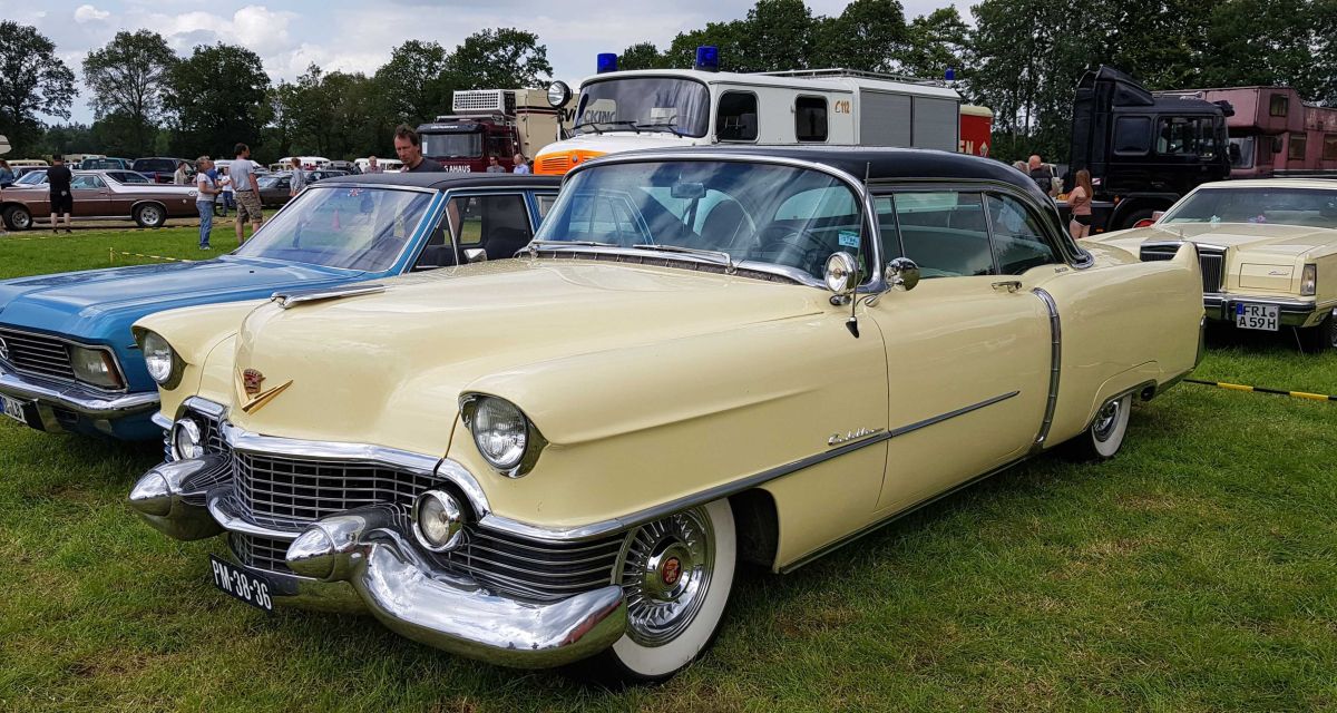 Zu sehen sind alte Pkw auf der Bockhorner Oldtimermarkt. Im Vordergrund steht ein cremefarbener Chevrolet, daneben ein blauer Opel. Im Hintergrund ist ein weiteres cremefarbenes amerikanisches Fabrikat zu sehen.
